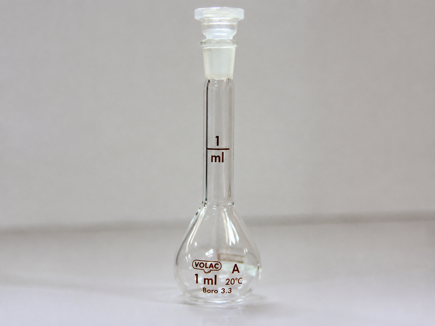 Small glass volumetric flask with measurement marking.